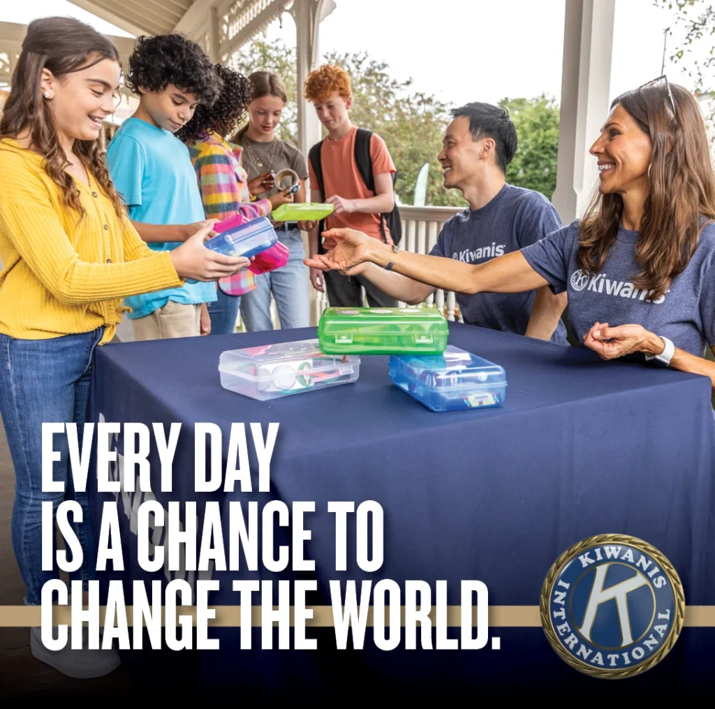 Kiwanis volunteers with children and the message: Every day is a chance to change the world.